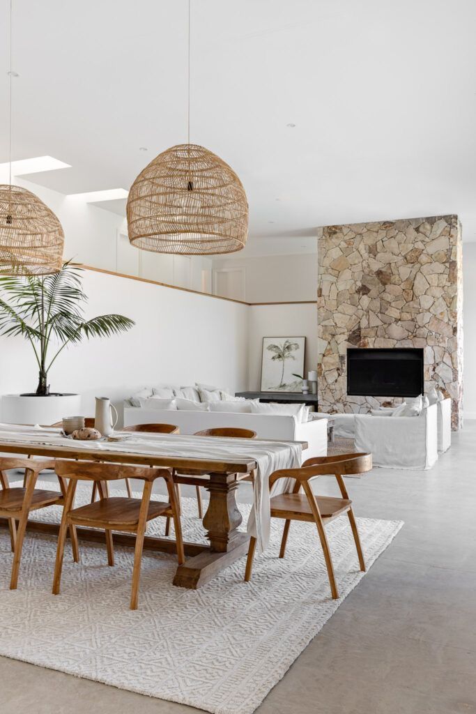 Coastal style dining room in the Costa del Sol with solid teak table, rattan chairs and natural stone fireplace – SYBARTUM