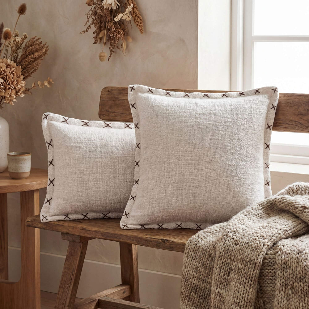 Styled interior setting featuring Crosswave cushions on a wooden bench with soft natural textiles.