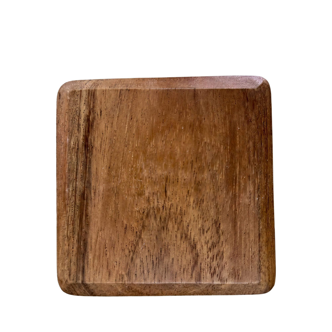 Top view of a single acacia coaster showing its square shape and natural wood grain.