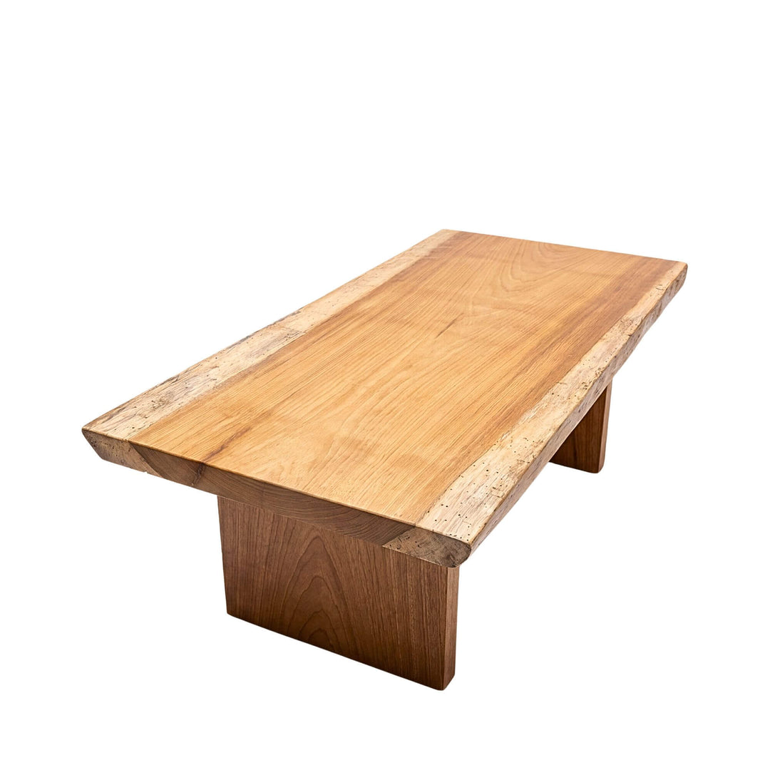 Front angled view of the Acacia coffee table with a solid rectangular top, natural edges, and panel-style wooden legs