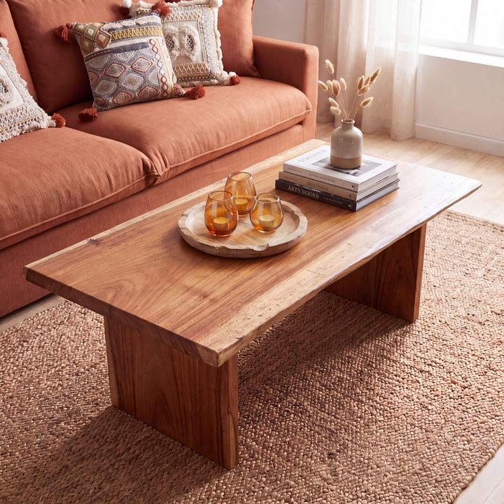 Acacia coffee table styled with books and decorative objects in a warm Mediterranean-inspired living room
