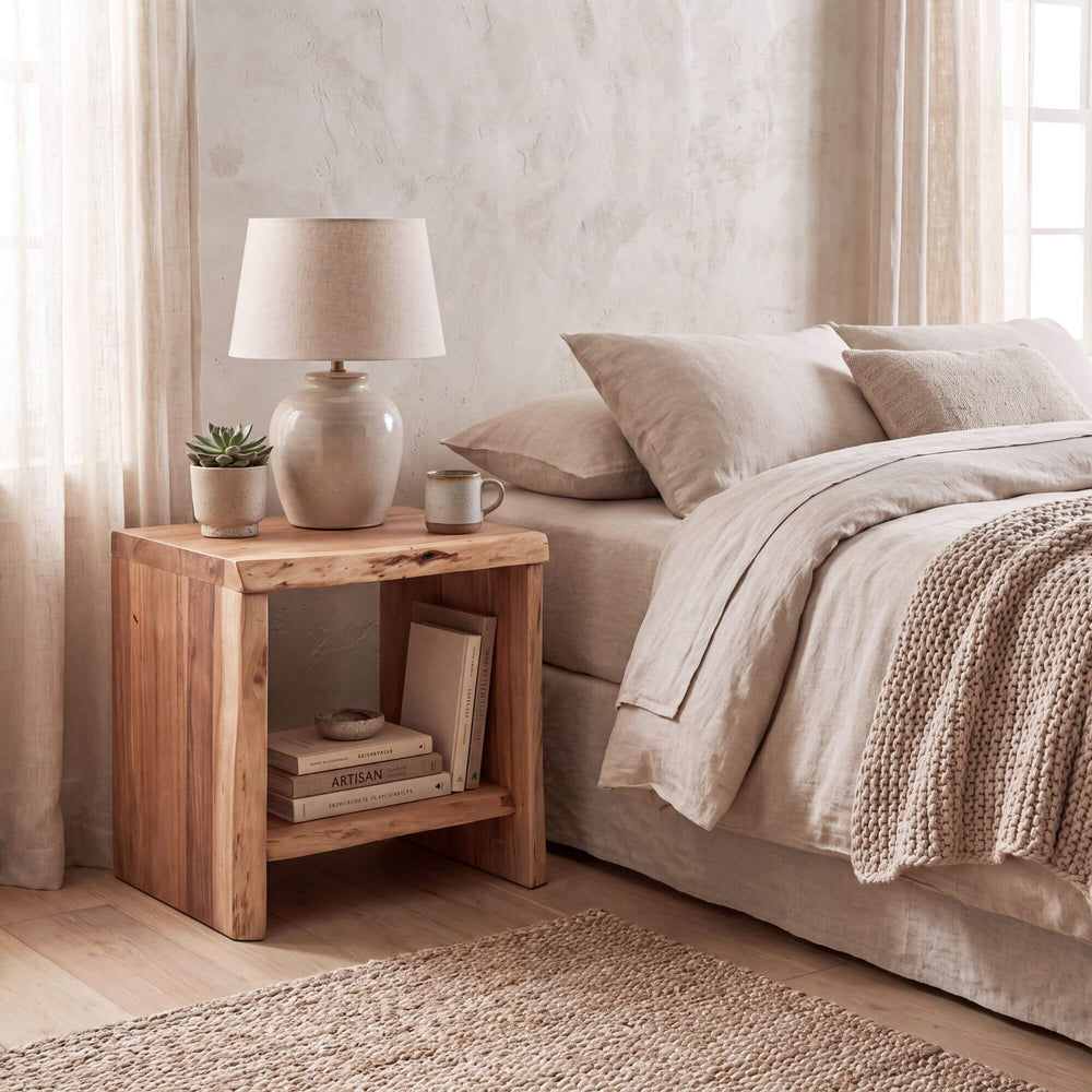 Acacia Edge bedside table styled beside a bed in a warm neutral bedroom