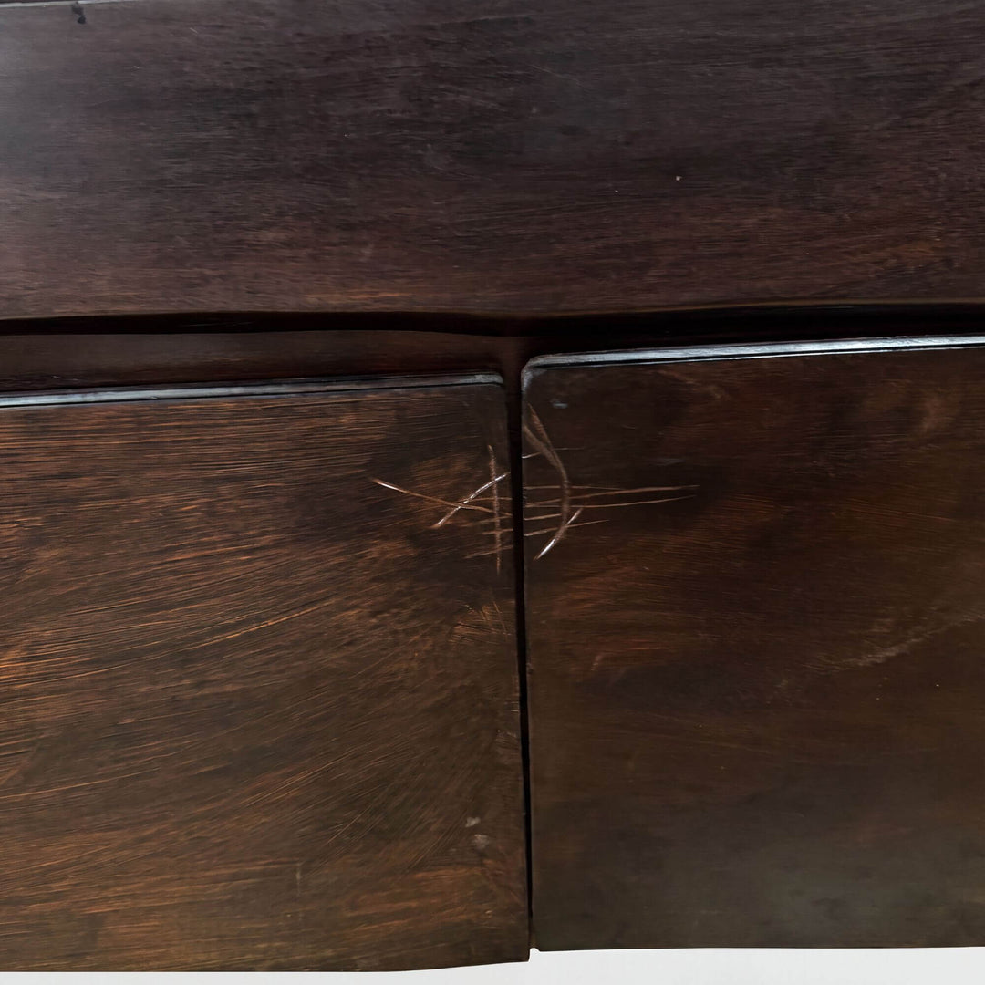 Close-up detail of the cabinet doors showing the rich acacia wood grain, deep brown tones, and natural texture.