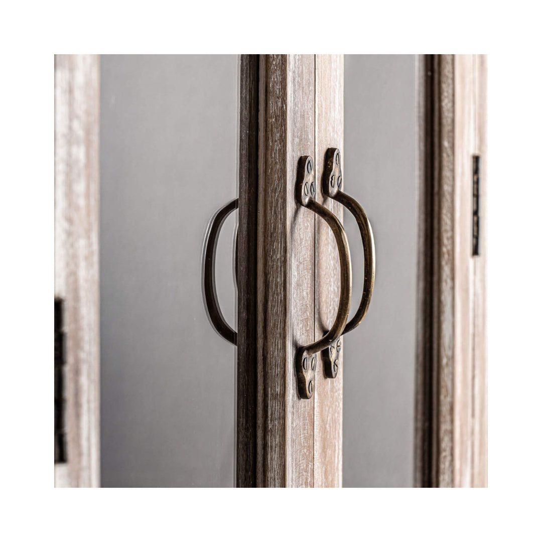 Close-up of the glass cabinet doors with brass ring handles on the Adrastea wardrobe.