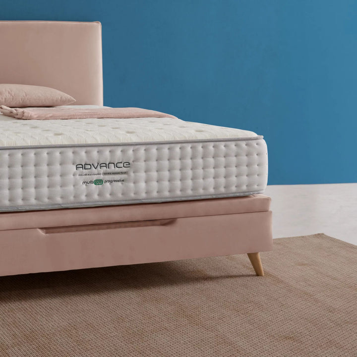 Angled bedroom shot showing the Advance Mattress in a modern interior.