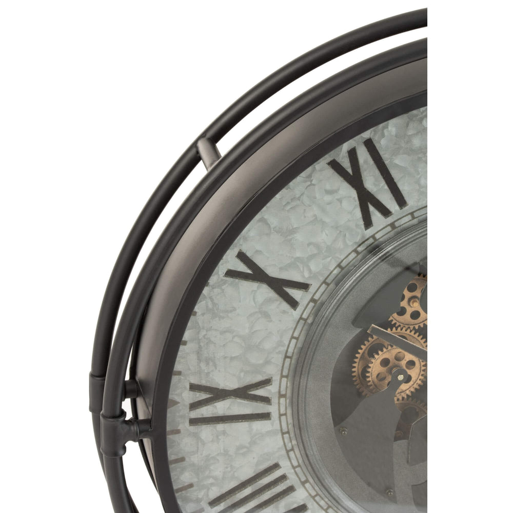 Close-up of Aion Roman Clock showing metal frame, Roman numerals, and exposed bronze gears