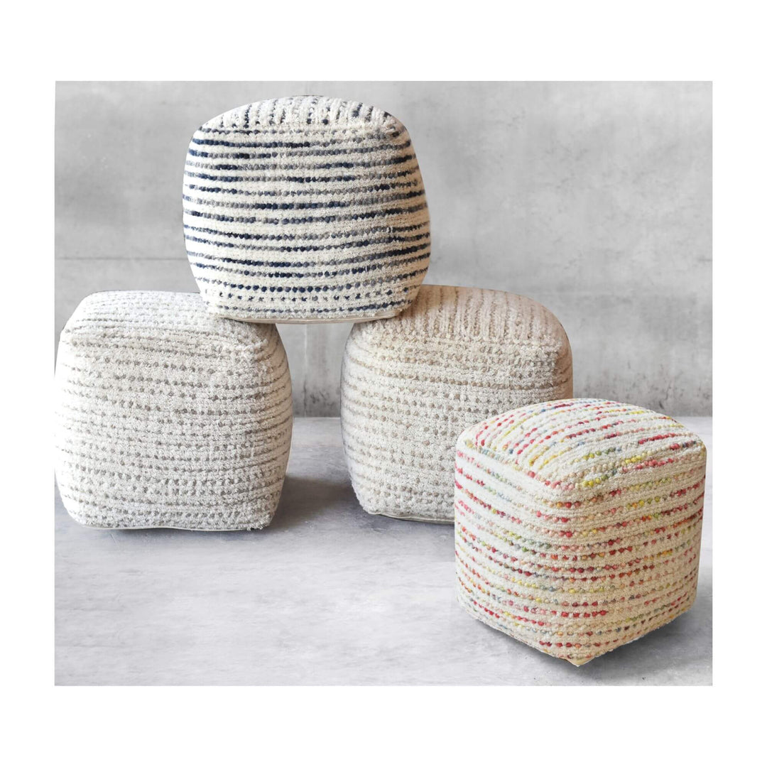 Group of Aksa wool poufs in assorted natural tones and patterns.