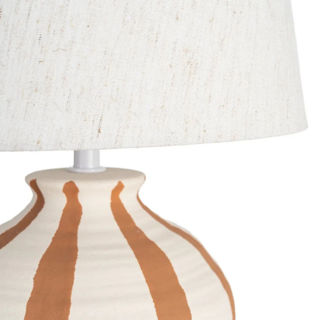 Close-up detail of the ceramic base and textile lampshade showing the artisanal finish.