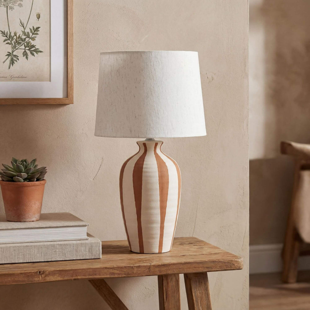 Styled interior setting featuring the Alba table lamp on a wooden console in a warm natural space.