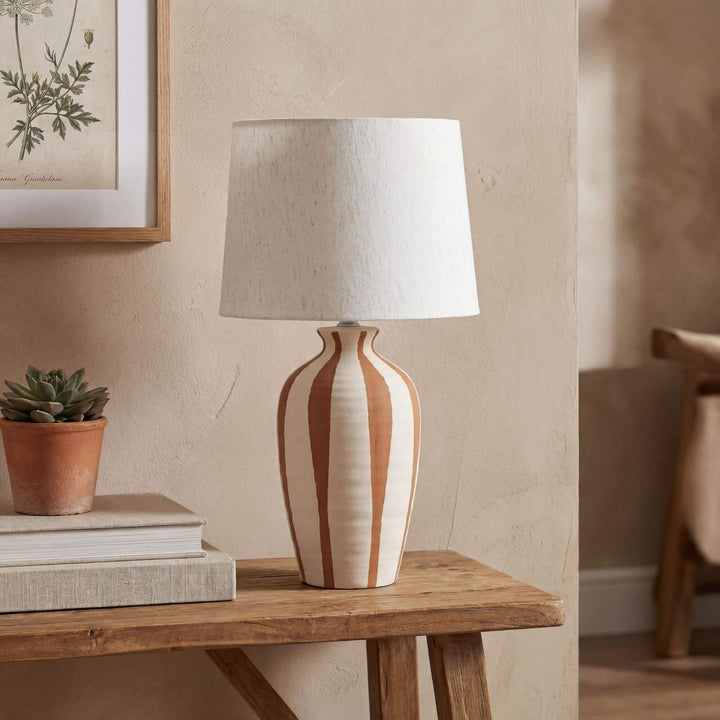 Styled interior setting featuring the Alba table lamp on a wooden console in a warm natural space.