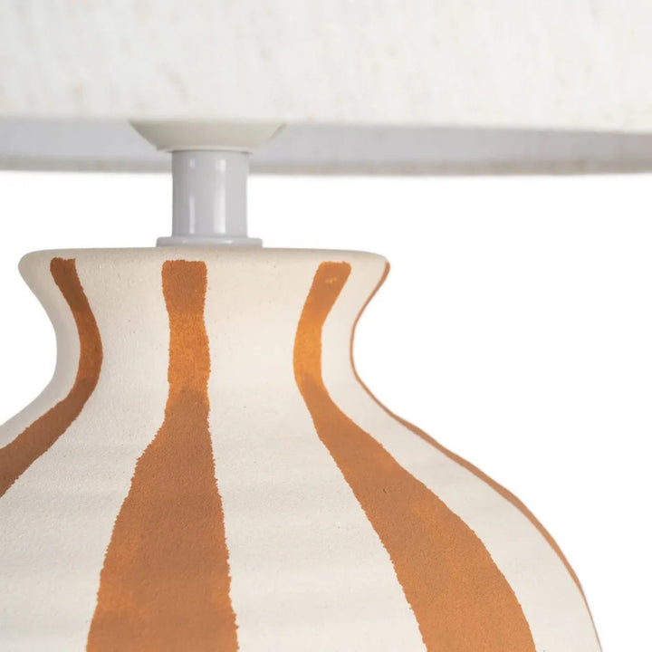 Close-up detail of the ceramic base and textile lampshade showing the artisanal finish.
