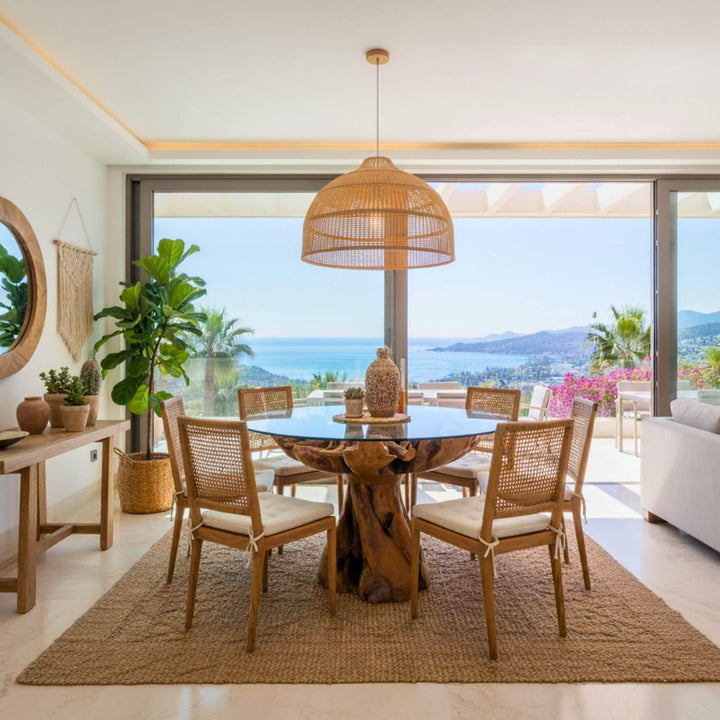 Dining area with Aldebaran Root Dining table and chairs, large sliding glass doors, and scenic view.