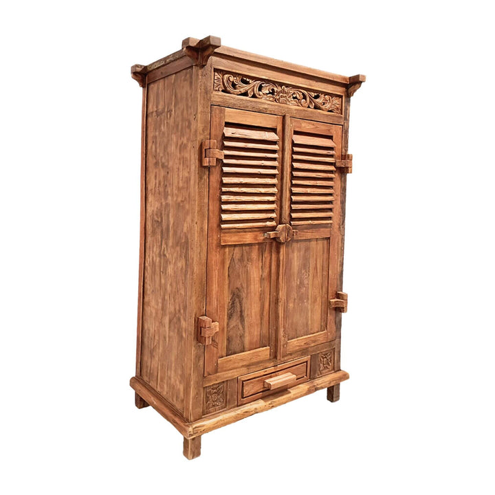 Angled view highlighting carved details and louver panels on teak wardrobe.