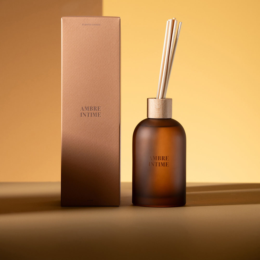 Lifestyle setting showing the Amber Intime Diffuser placed on a warm-toned surface.