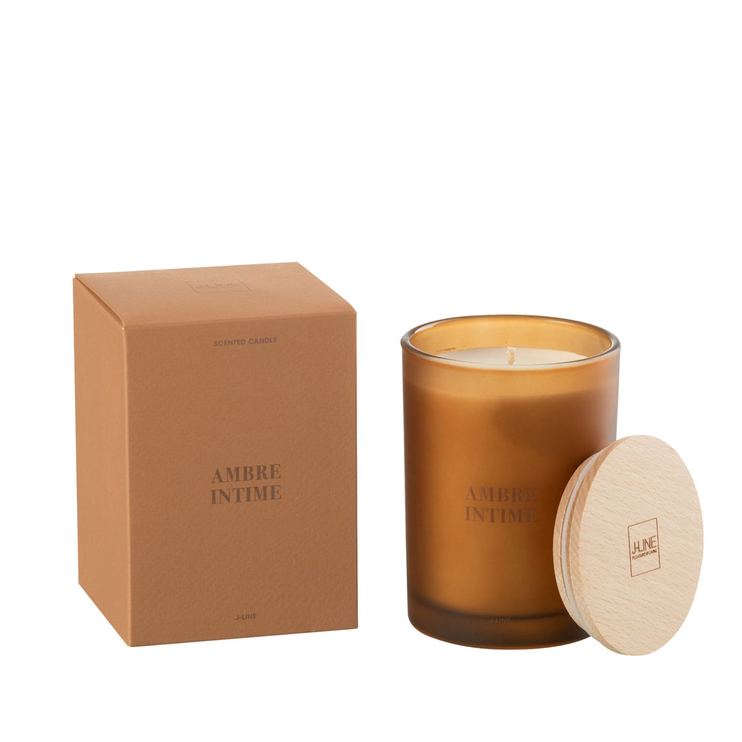 Amber Intime scented candle with amber glass jar and wooden lid next to its packaging.