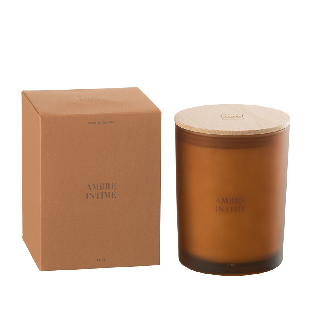 Amber Intime scented candle with amber glass jar and wooden lid next to its packaging.