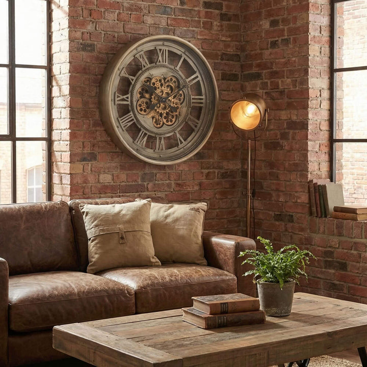 Styled industrial living room featuring the Ananke Roman clock mounted on a brick wall above a sofa.