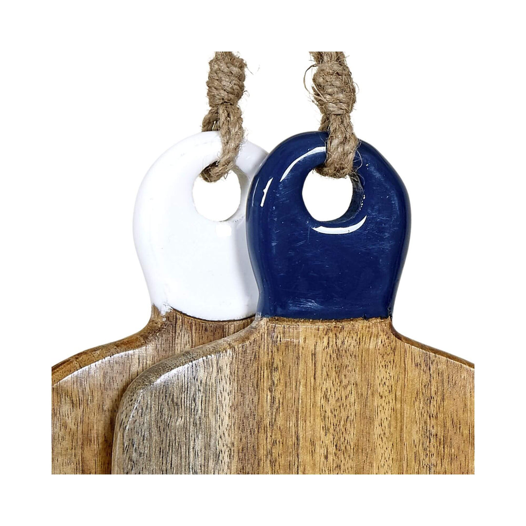 Close-up of two mango wood chopping boards with glossy ceramic handles in navy and white, hanging by jute rope.