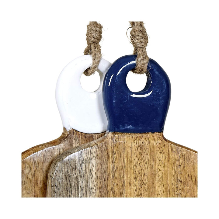 Close-up of two mango wood chopping boards with glossy ceramic handles in navy and white, hanging by jute rope.