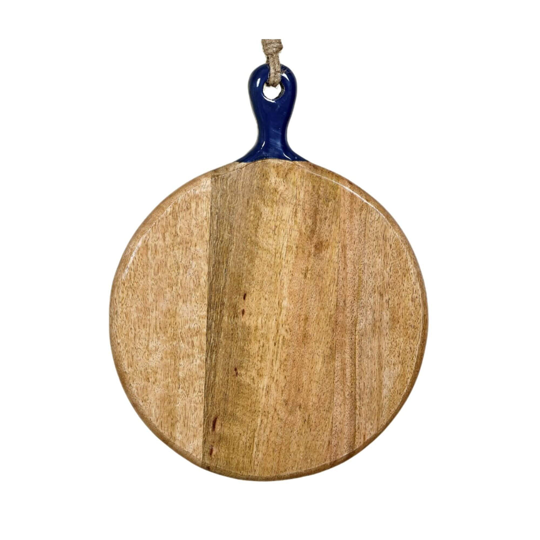 Anaya round chopping board made of mango wood with a navy ceramic handle, hanging by a jute rope.