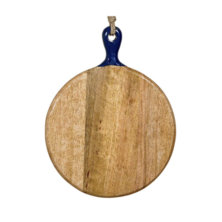 Anaya round chopping board made of mango wood with a navy ceramic handle, hanging by a jute rope.