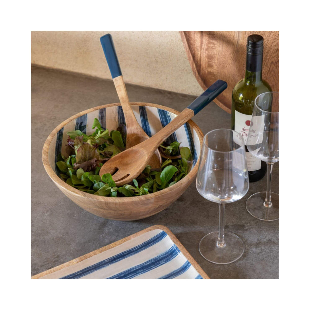 Wooden salad bowl with blue-striped interior accompanied by a natural wood salad set with navy handles.