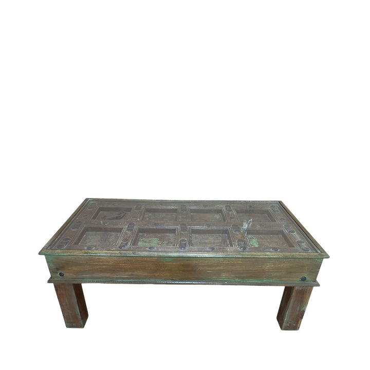 Front view of the antique door coffee table showcasing its carved tabletop and solid wood legs.