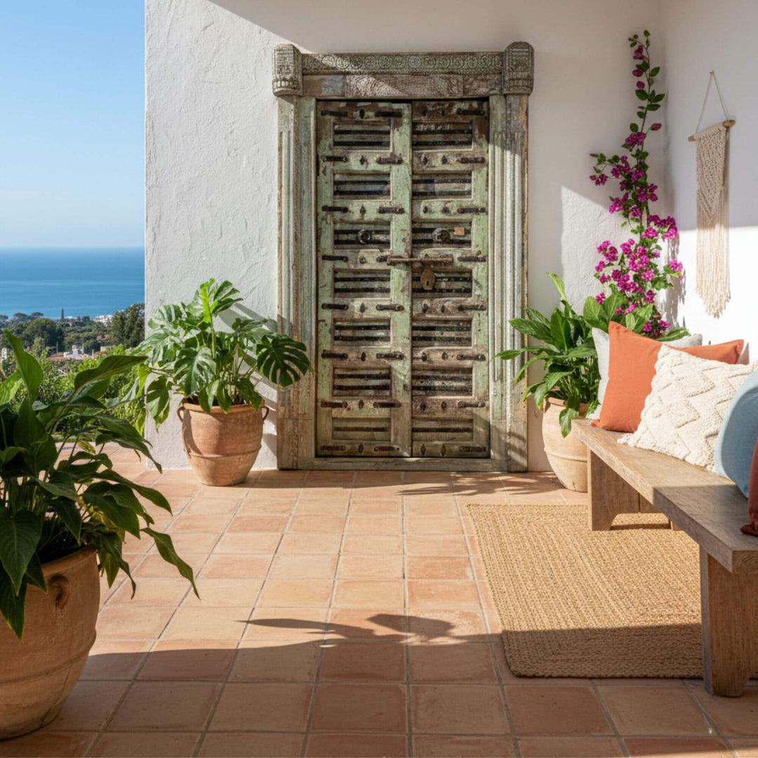 Outdoor terrace setting featuring the antique carved Indian door as a decorative focal point.