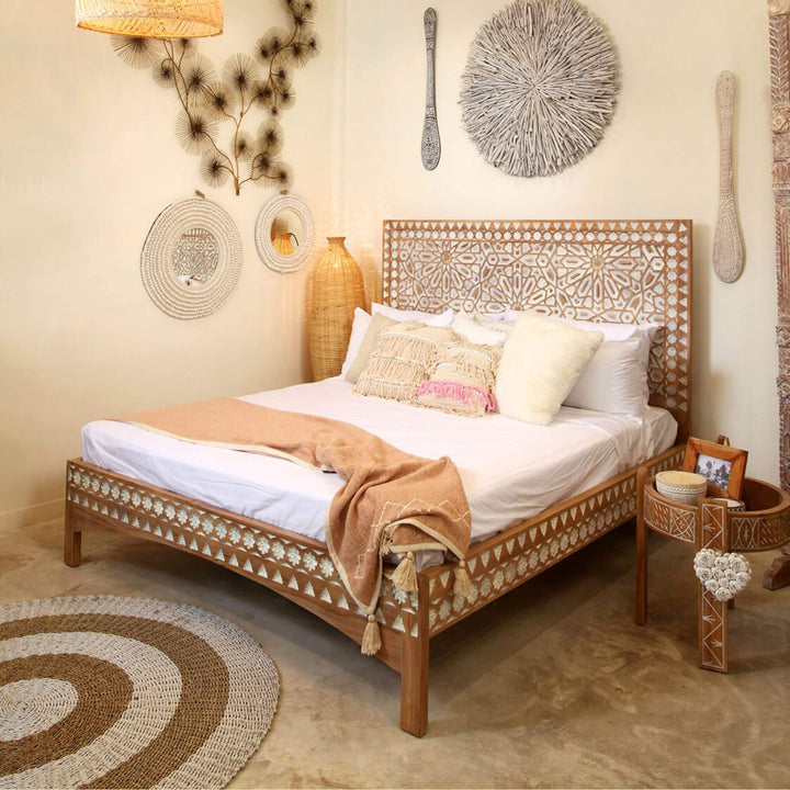 Bedroom scene featuring Aphrodite teak wood table and matching carved furniture