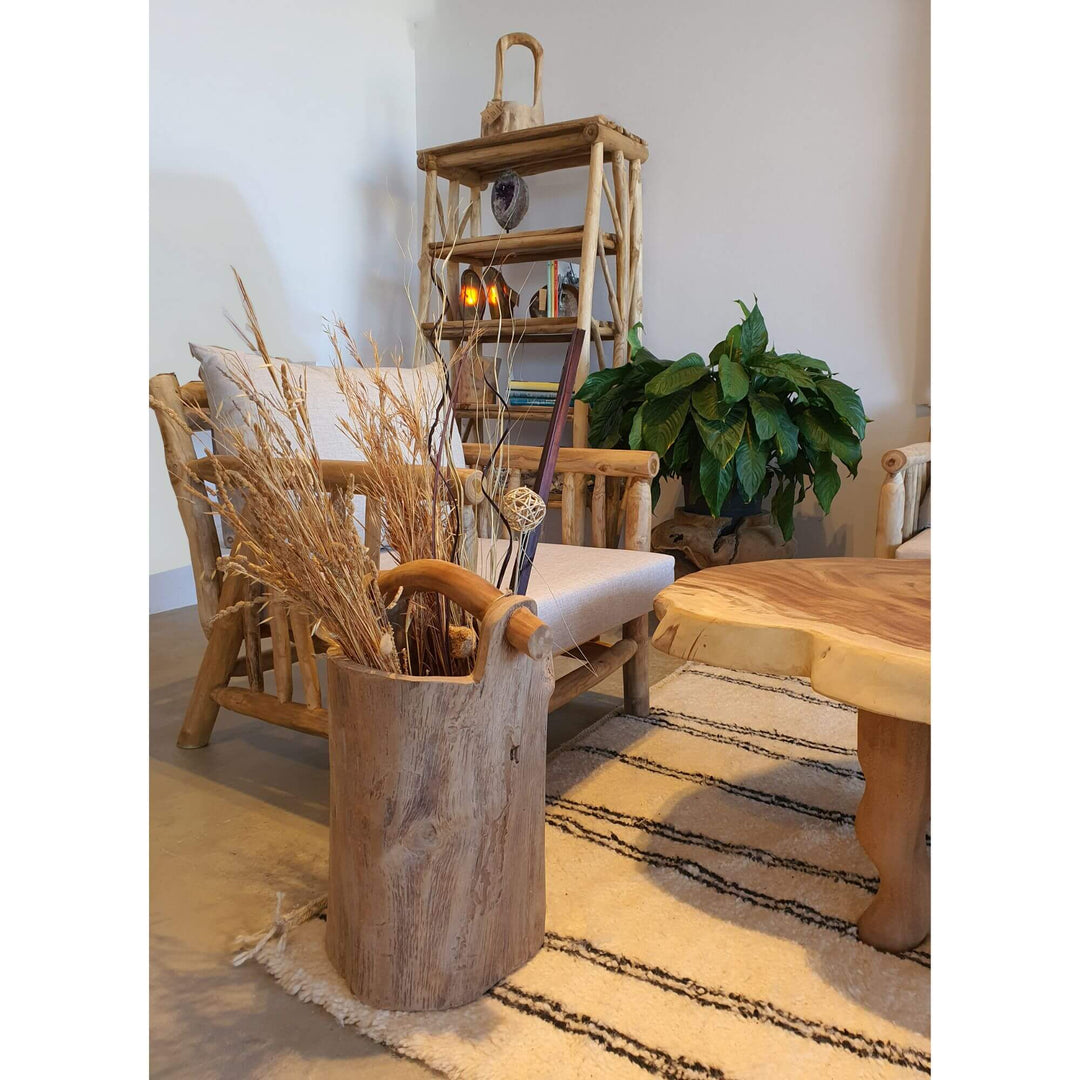 Teak pot styled in a natural living room setting with dried branches.