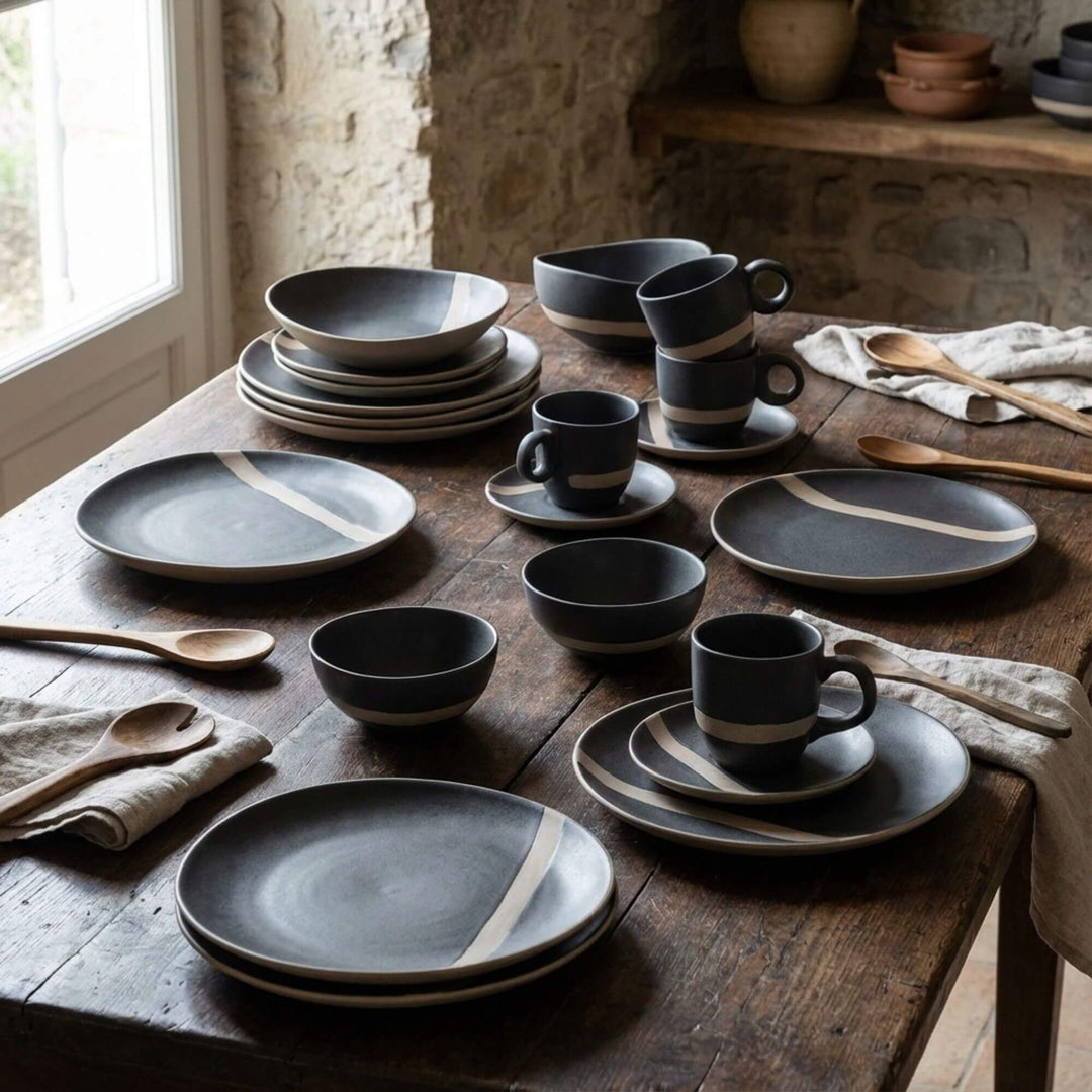 Arcai tableware collection styled on a rustic dining table with plates, bowls, and cups.