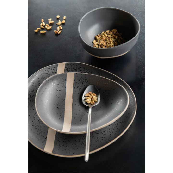 Arcai tableware collection styled on a black dining table with plates and bowls