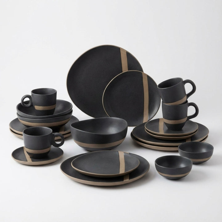 Arcai tableware collection styled on a rustic dining table with plates, bowls, and cups.