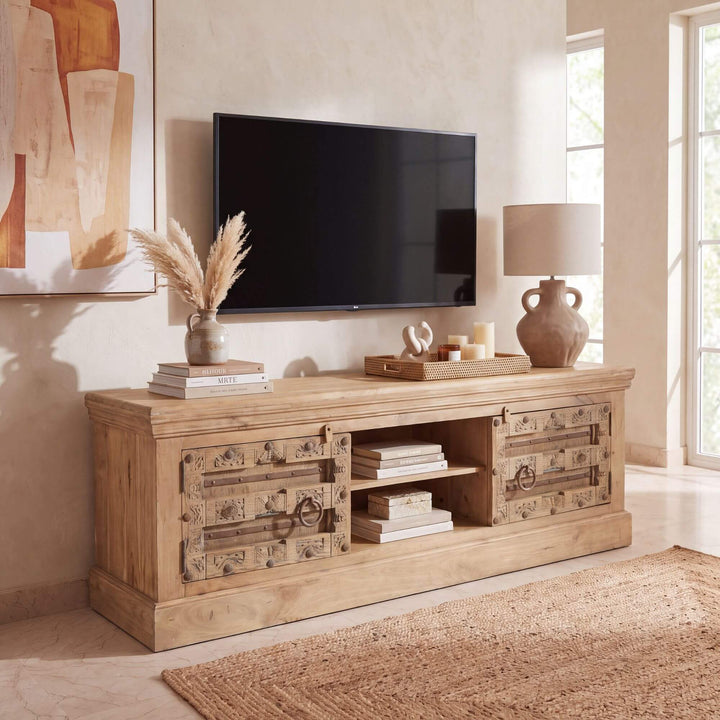 Aruna Briss mango wood TV console styled beneath a television in a warm Mediterranean-inspired living room