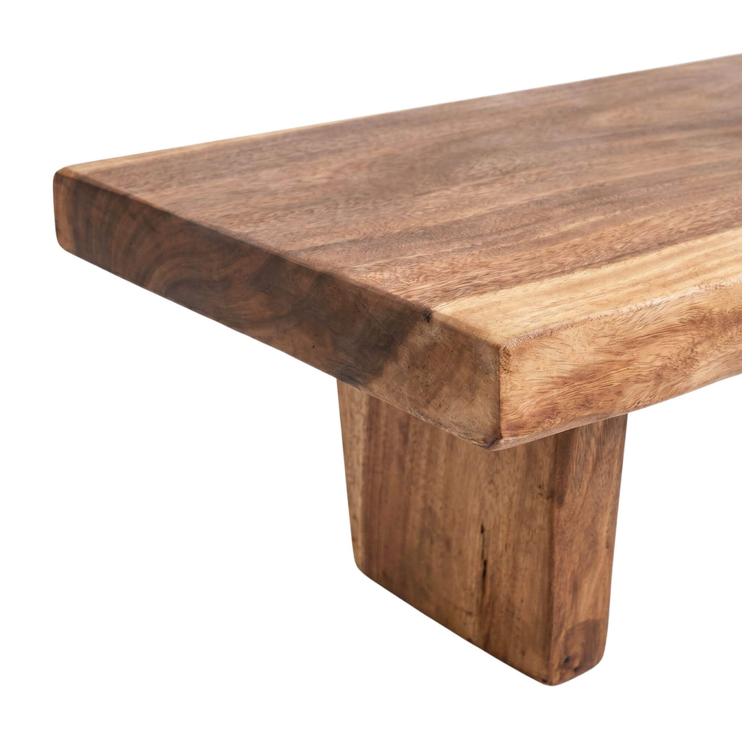 Close-up detail of the tabletop edge and leg showing the natural suar wood grain.