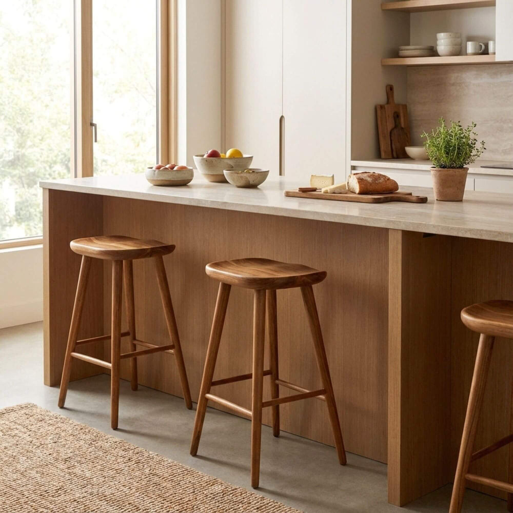 Styled interior view of Banana Bar Stool placed at a kitchen island, highlighting its warm wood tones.