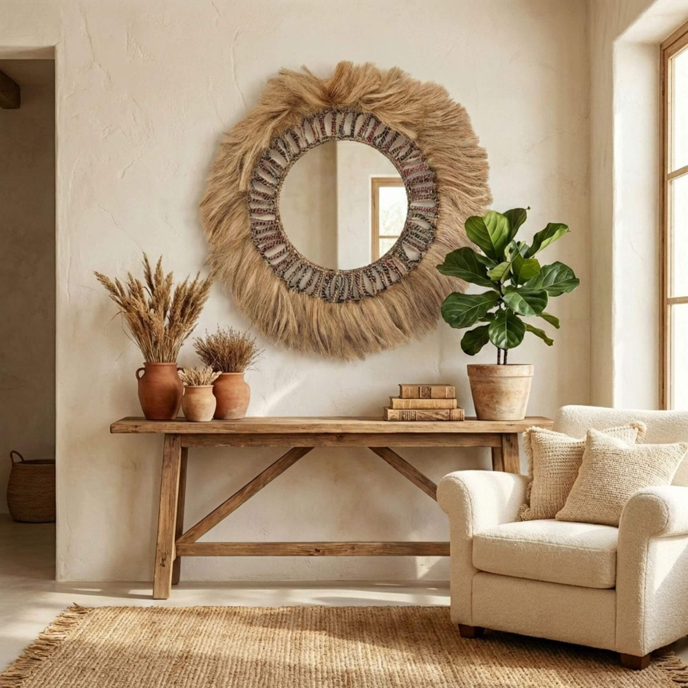 Nestled living room with a textured wall Banyu mirror, wooden table, and beige armchair.