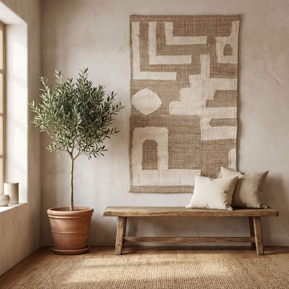 Nest living room with a wooden bench, potted plant, and abstract Baringo tapestry.