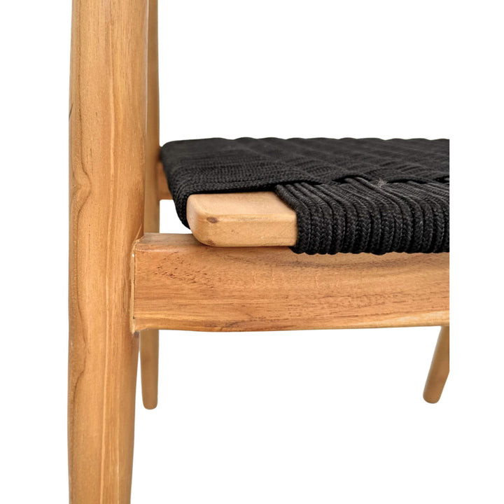Side detail of Baros Dining Chair showing teak frame and woven black rope seat.