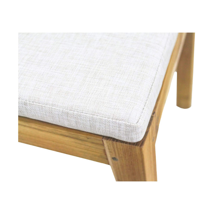 Close-up view of Batanta Teak Dining Chair cushioned seat in light fabric.