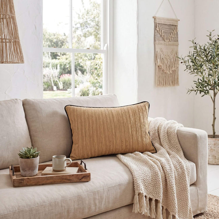 Styled interior setting featuring the Beach Natural cushion on a sofa with soft neutral textiles.