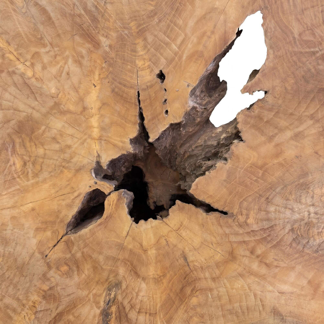 Close-up detail of the tabletop showing the natural opening and rich teak grain.