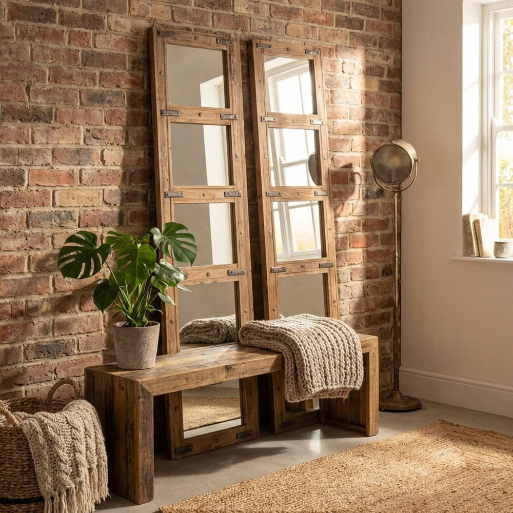 Wooden bench with Bentaneil mirror against a brick wall in a room with natural light.