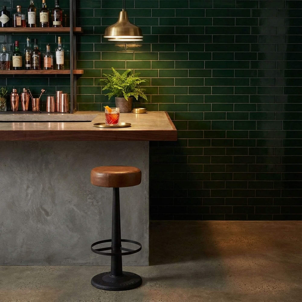 Bar area with a wooden counter, Bill bar stool, and green tiled wall.