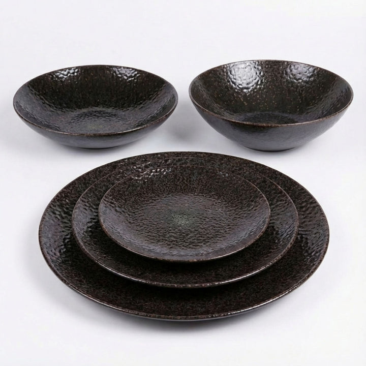 Set of Black Basalte tableware made of basalt with textured surface on white background.