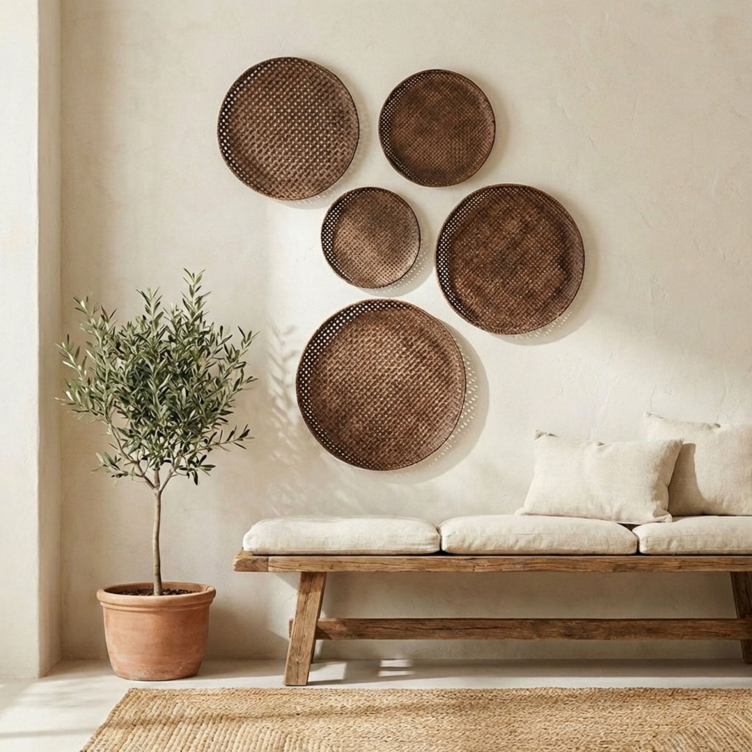 Bogoria bamboo plate collection wall art pieces on a neutral wall above a wooden bench with cushions.