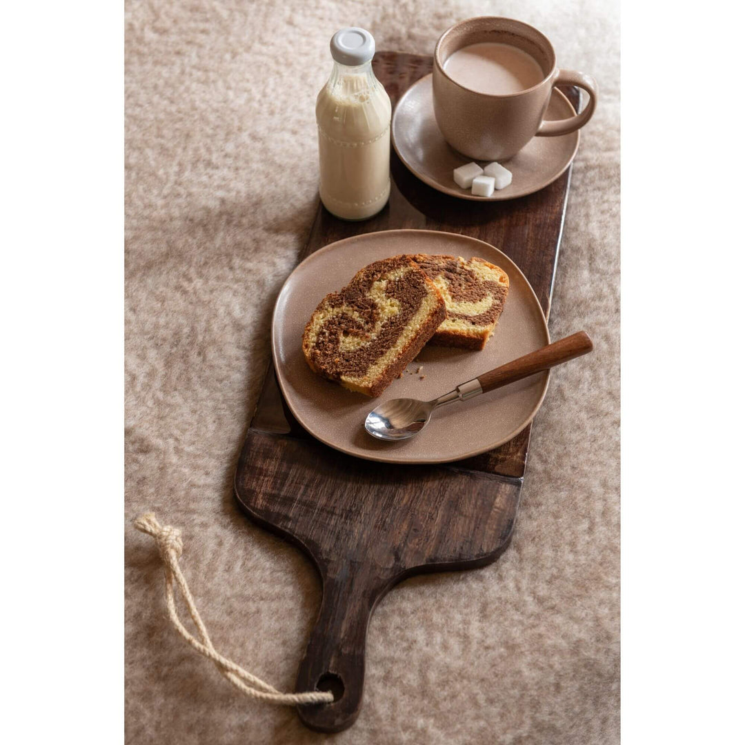 Brown Plake Chop Board in use with pastries, milk bottle, and coffee on warm textured surface.