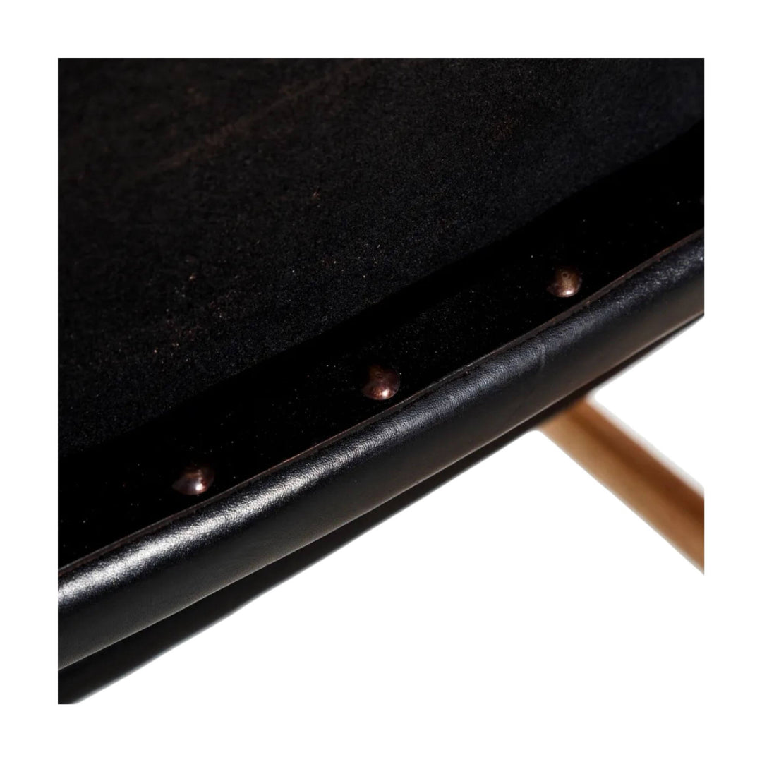 Close-up of leather seat edge with decorative metal studs.