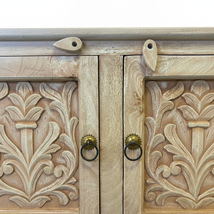 Close-up of the cabinet doors highlighting intricate floral carvings.