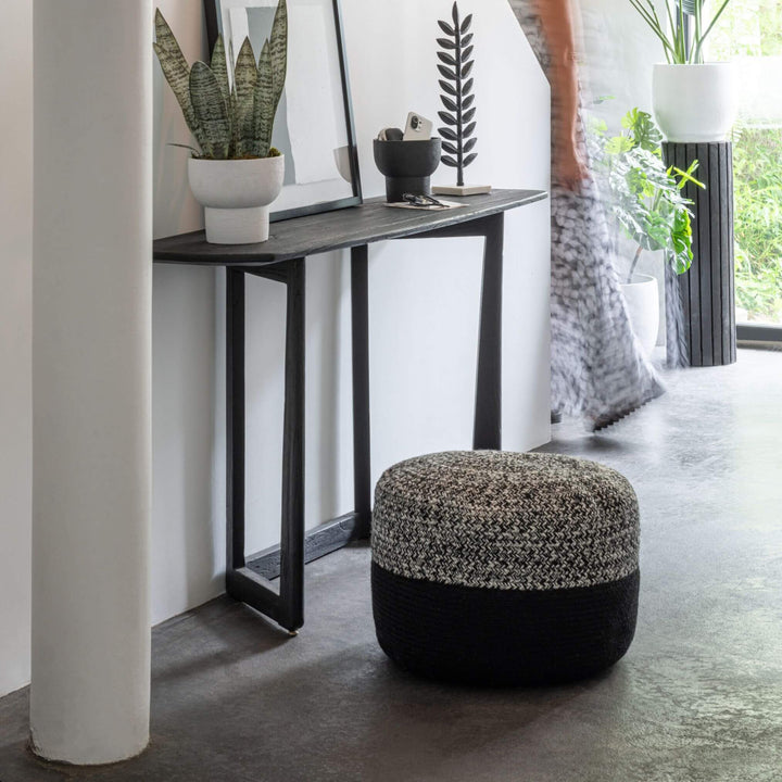 Black acacia console styled in a modern entryway with decor.